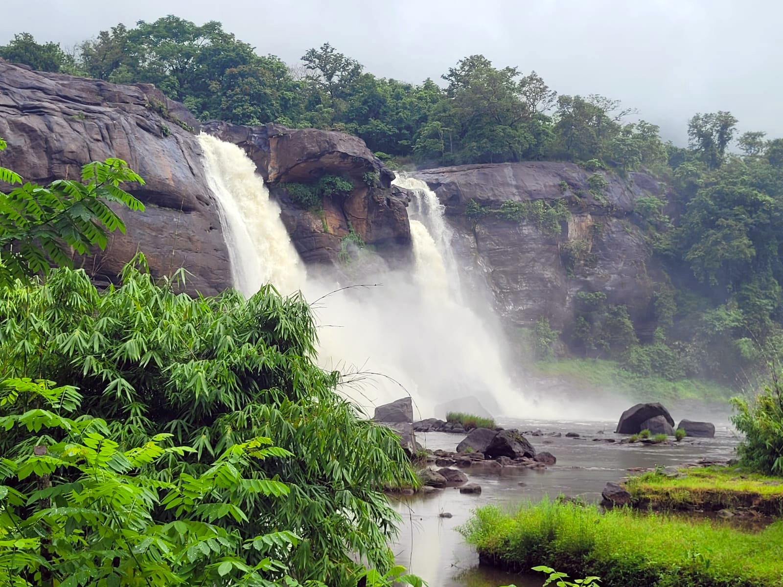 Athirapally Falls in Kerala with increased monsoon water flow surrounded by lush green forests